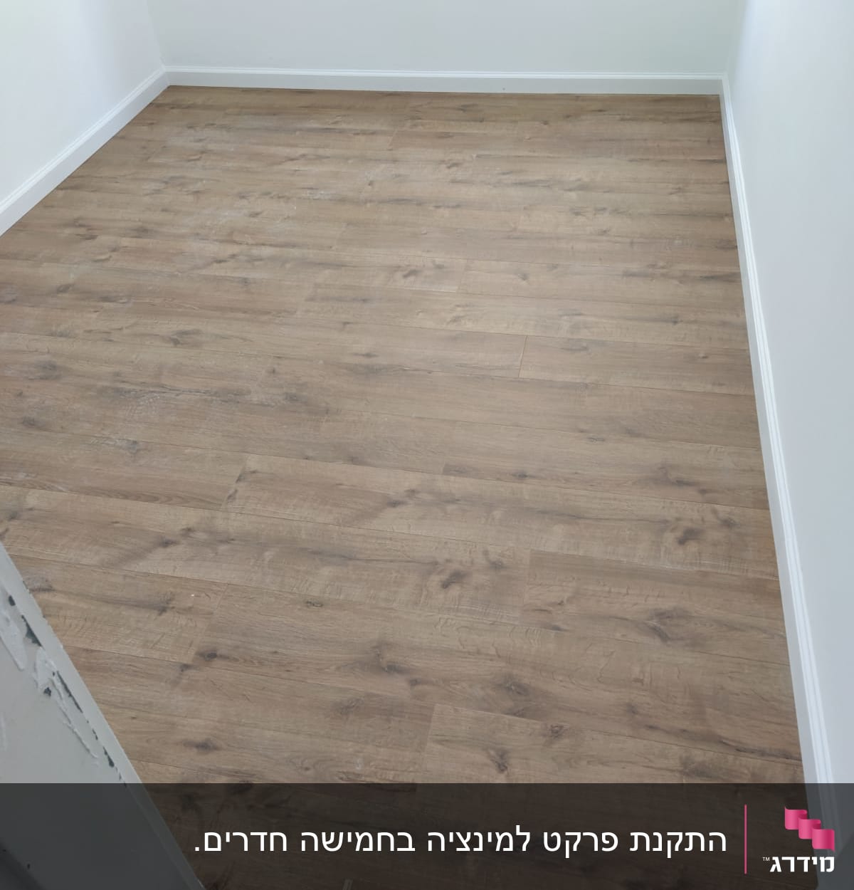 רצפת פרקט עץ בחדר עם קירות לבנים